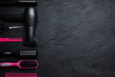 Photo of Flat lay composition of professional hairdresser tools on dark grey table, space for text