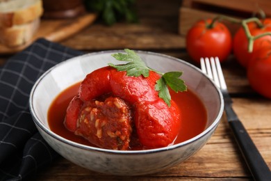 Photo of Delicious stuffed pepper with parsley in bowl on wooden table