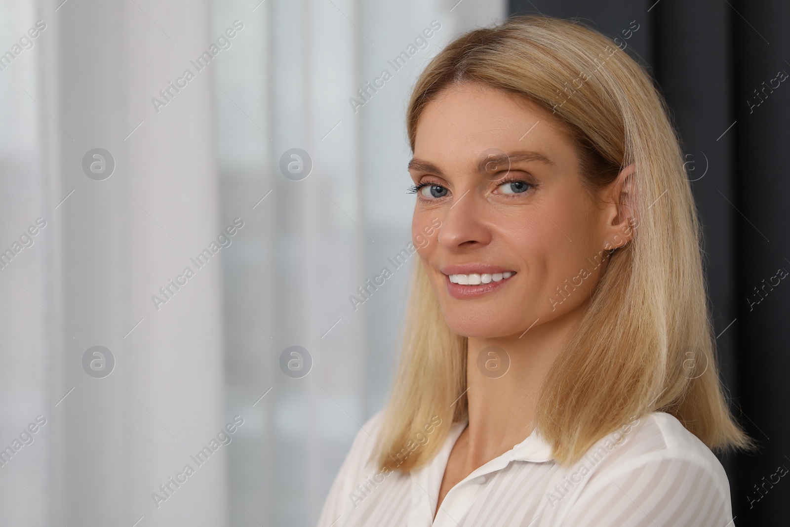 Photo of Portrait of confident entrepreneur or businesswoman, space for text. Beautiful lady with blonde hair smiling and looking into camera