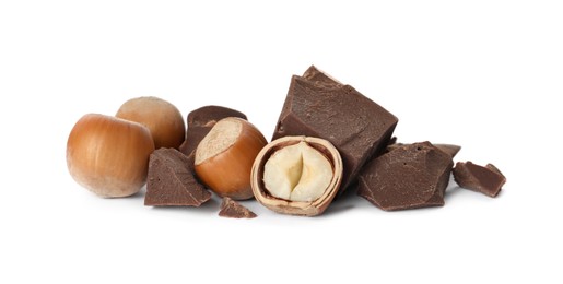Photo of Delicious chocolate chunks and hazelnuts on white background
