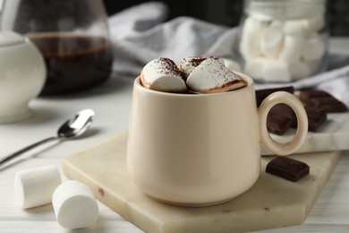 Photo of Cup of aromatic hot chocolate with marshmallows and cocoa powder on table, closeup