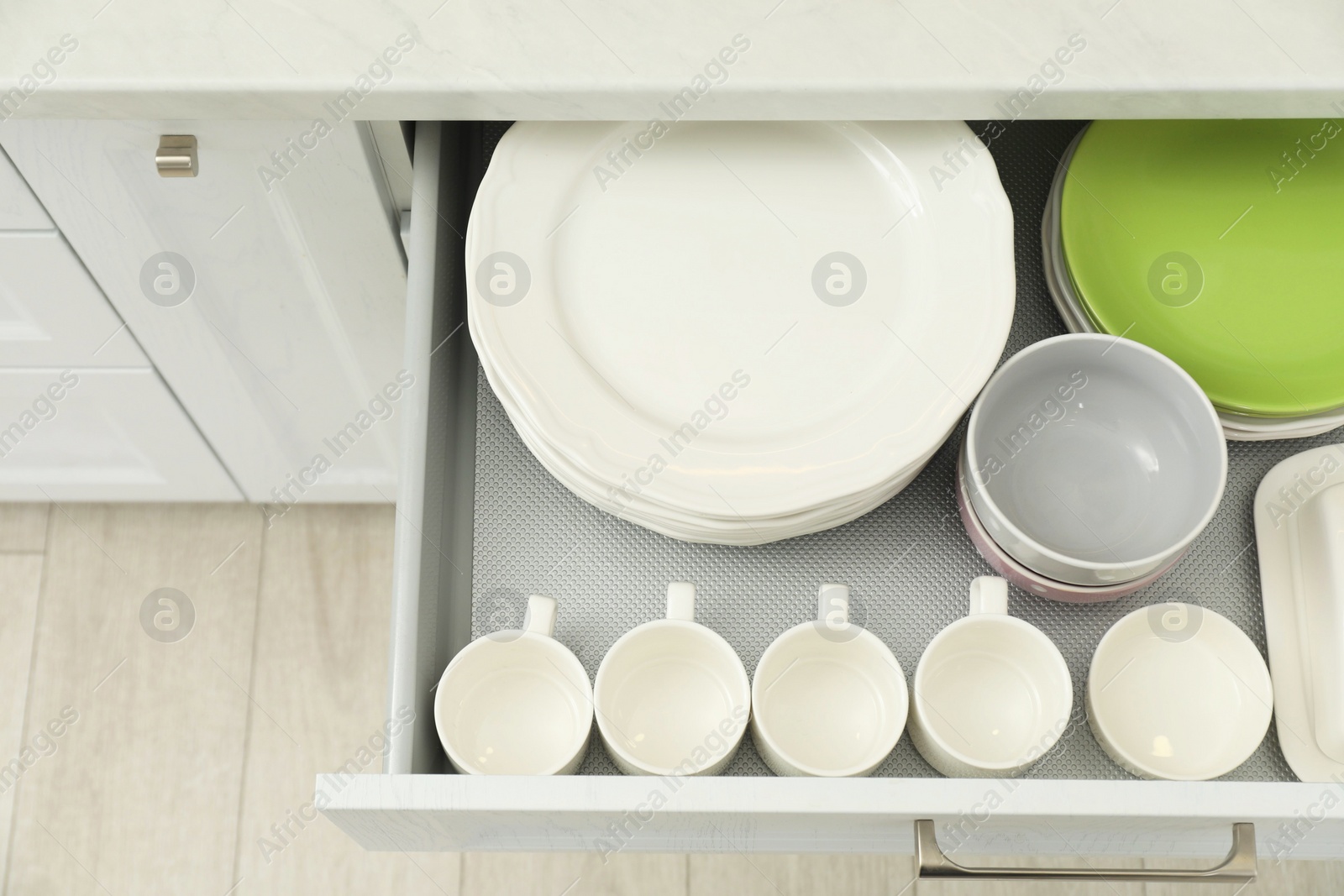 Photo of Clean plates, bowls and cups in drawer indoors, top view