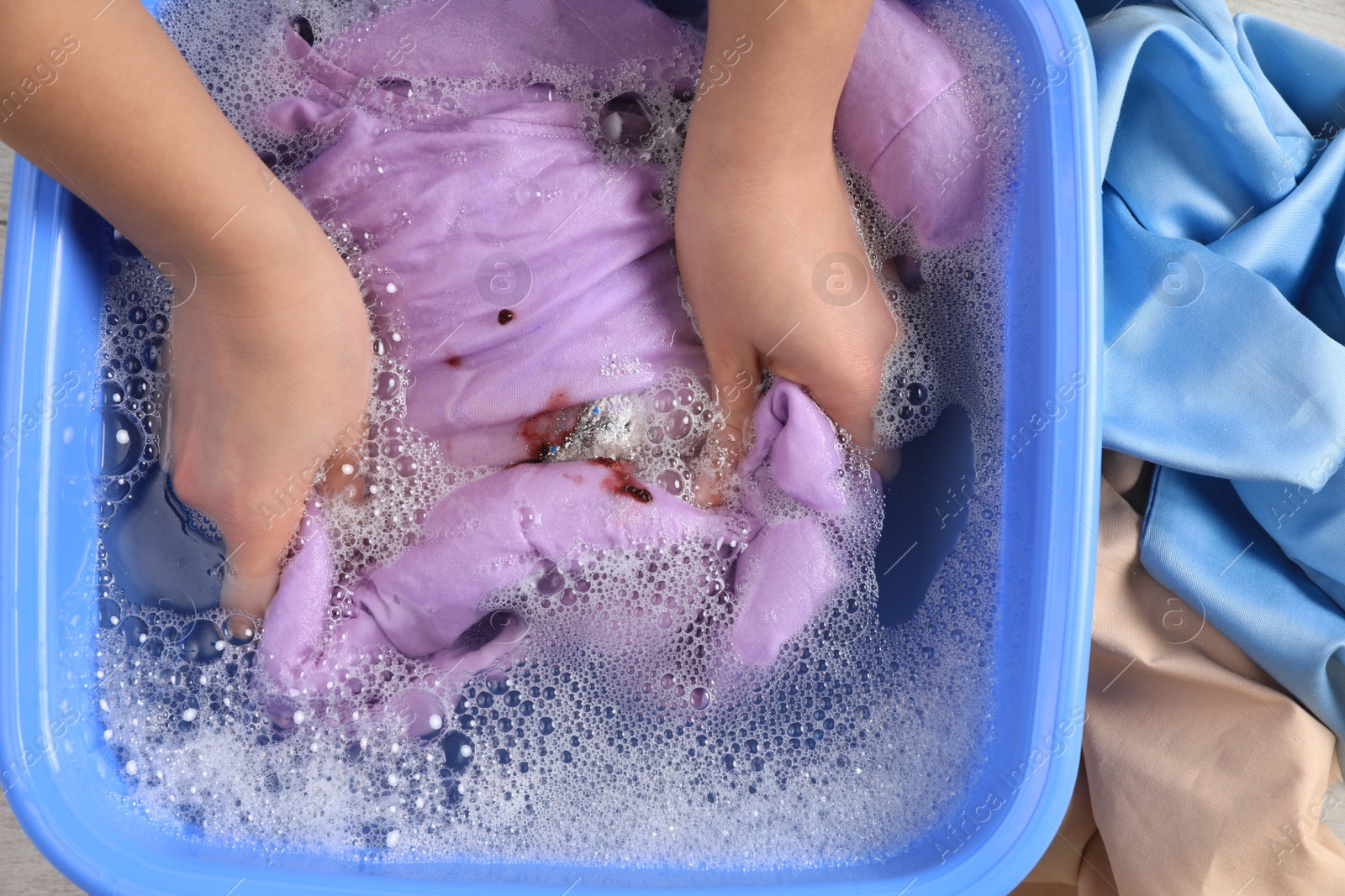 Photo of Woman washing garment with stain, top view