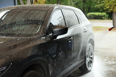 Photo of Washing auto with high pressure water jet at outdoor car wash