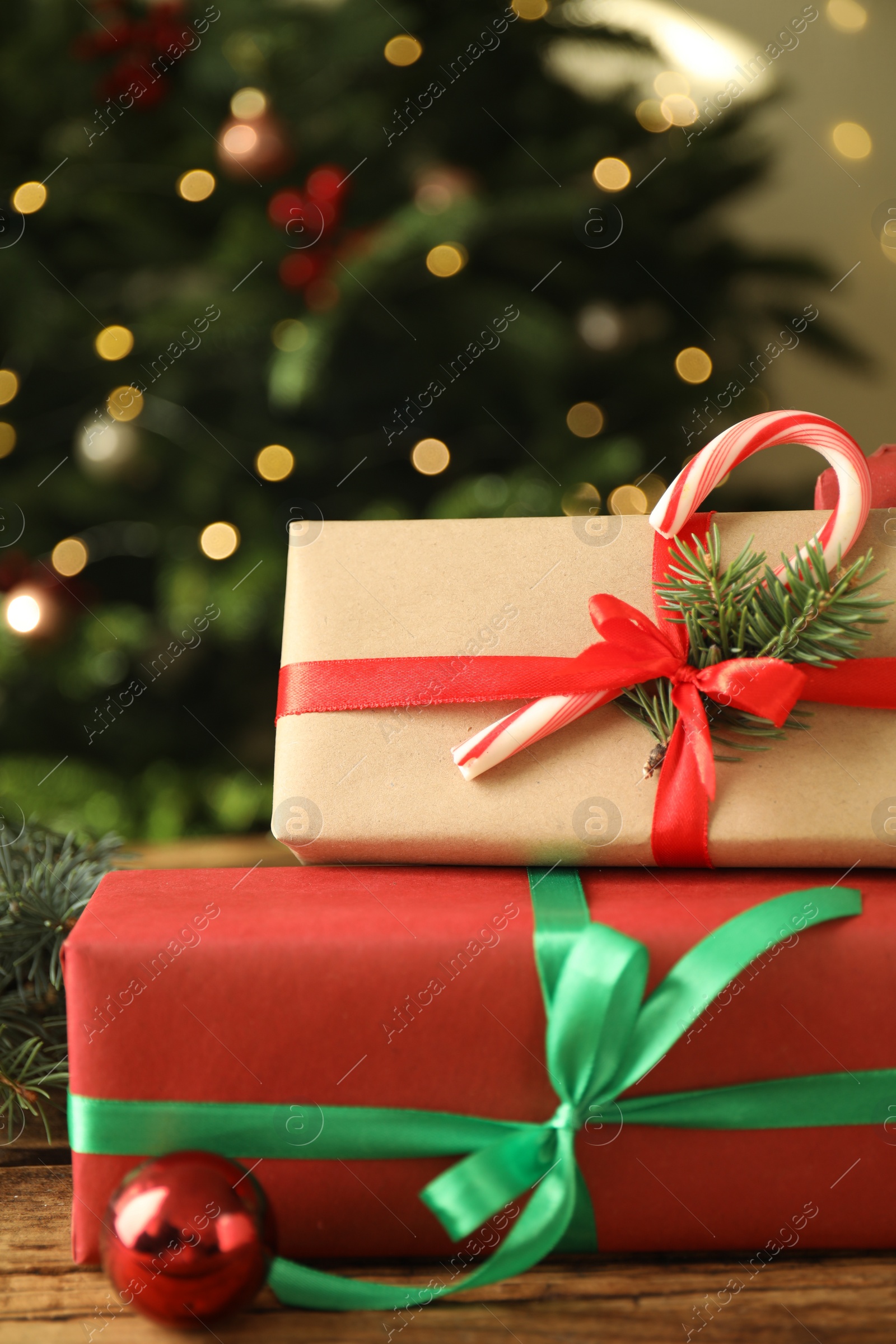 Photo of Beautiful gift boxes and Christmas decor on wooden table, closeup