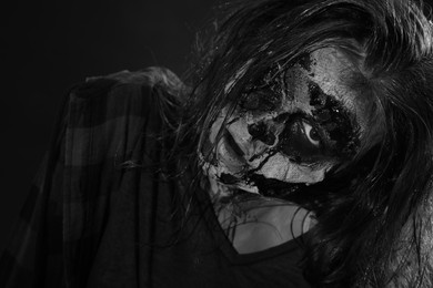 Scary zombie on dark background, black and white effect. Halloween monster