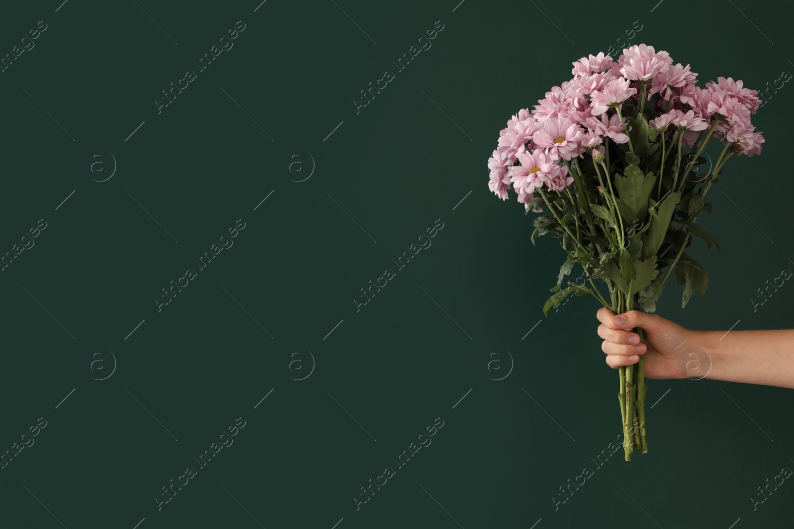 Photo of Woman holding beautiful bouquet near green chalkboard, space for text. Happy Teacher's Day