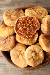 Photo of Bowl with tasty dried figs on wooden table, top view