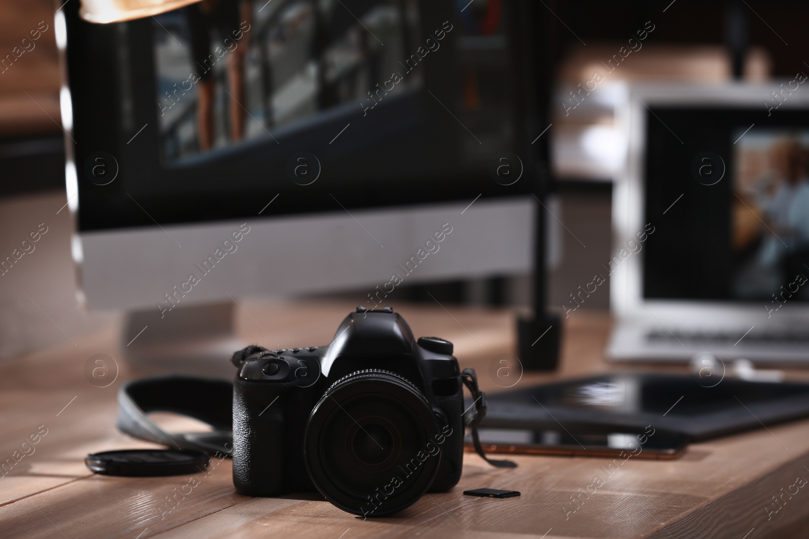 Photo of Retoucher's workplace. Professional camera on table indoors