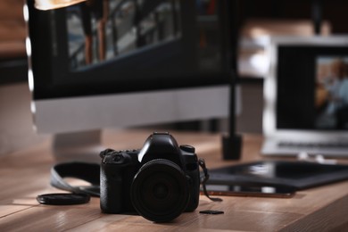 Photo of Retoucher's workplace. Professional camera on table indoors