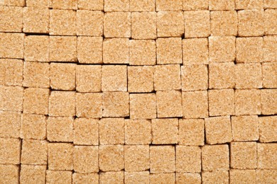 Photo of Brown sugar cubes as background, top view