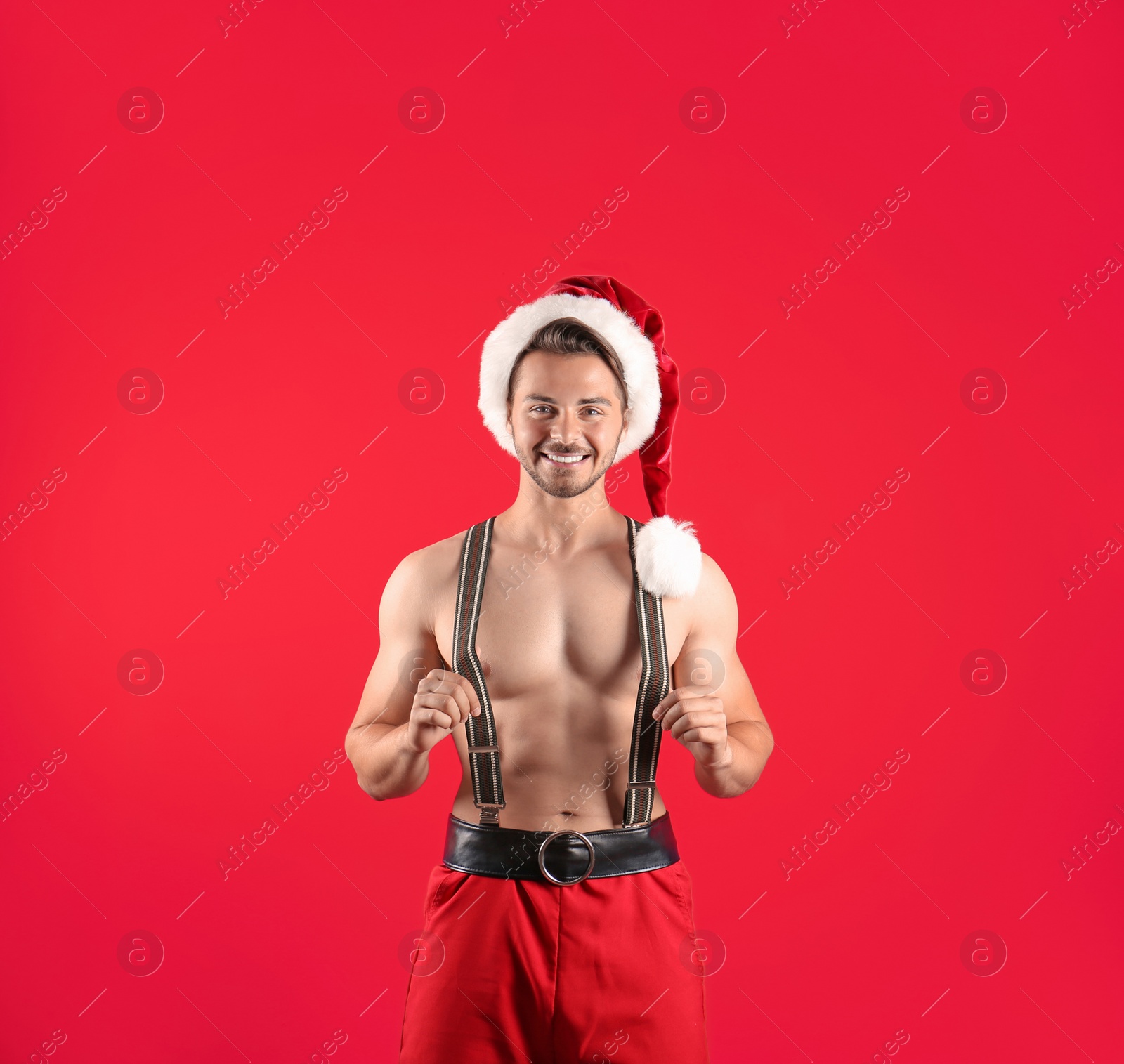 Photo of Shirtless young Santa Claus with sexy body on color background