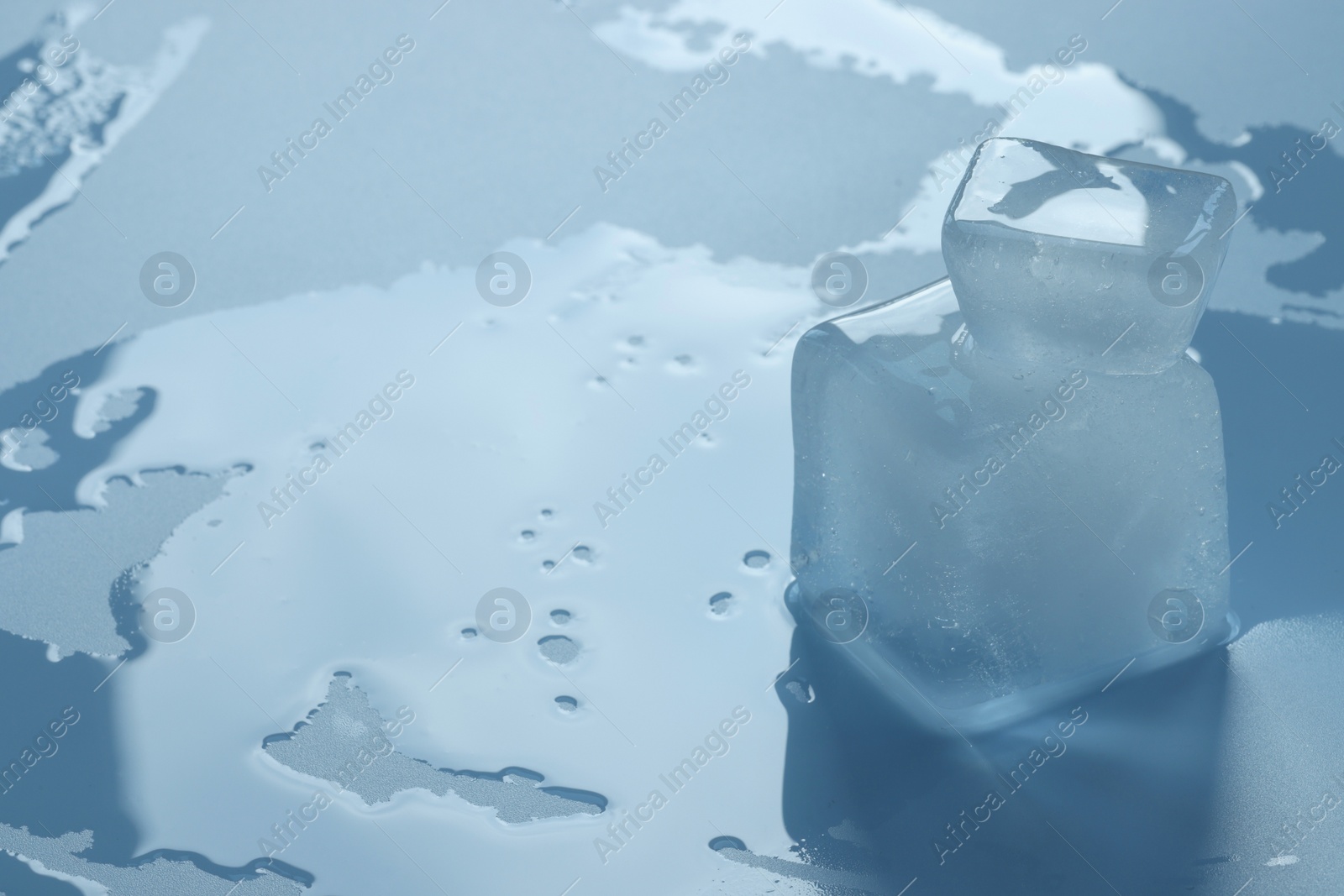 Photo of Crystal clear ice cubes on light blue background, space for text