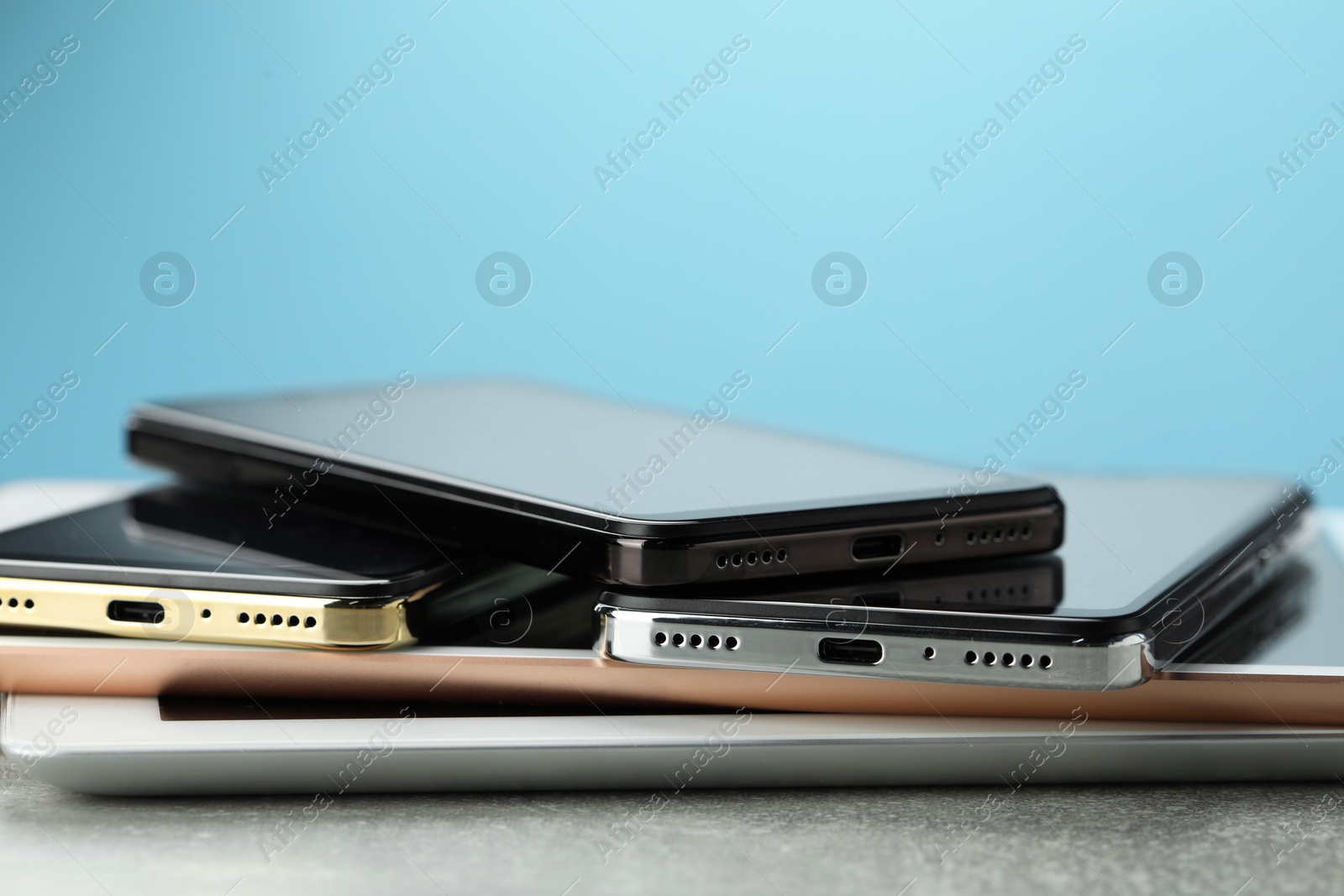 Photo of Stack of electronic devices on grey table, closeup