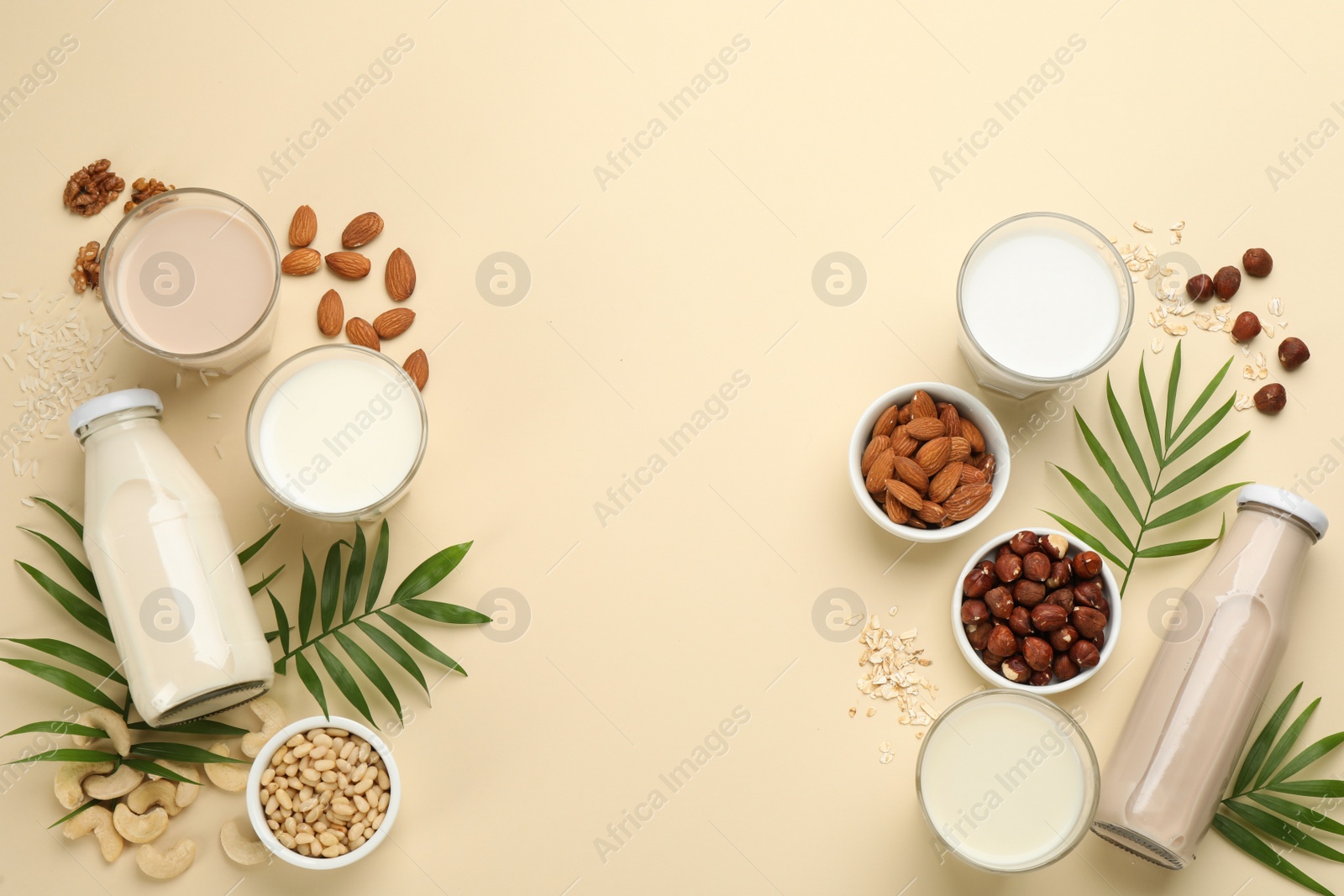 Photo of Different vegan milks and ingredients on beige background, flat lay. Space for text