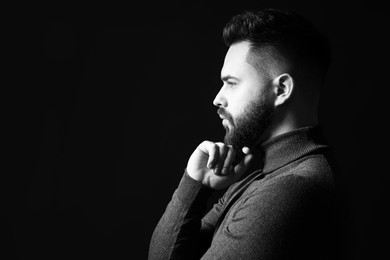 Photo of Portrait of handsome bearded man on dark background, space for text. Black and white effect