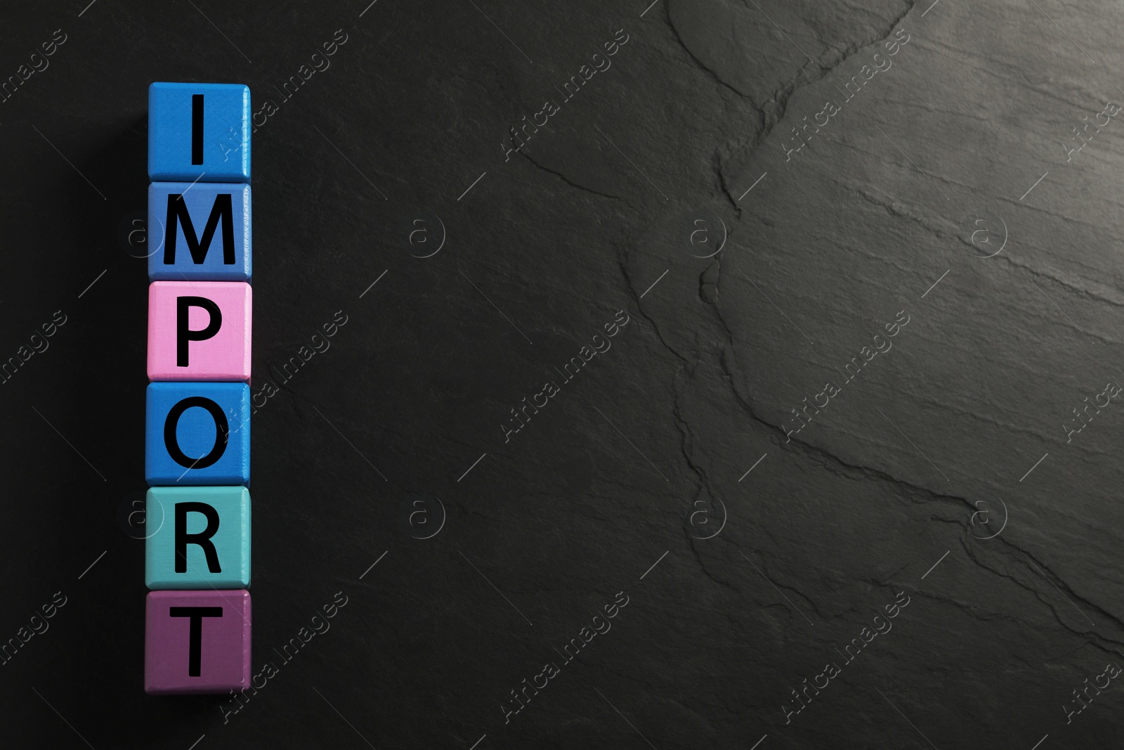 Photo of Word Import made of color cubes on black background, top view, Space for text