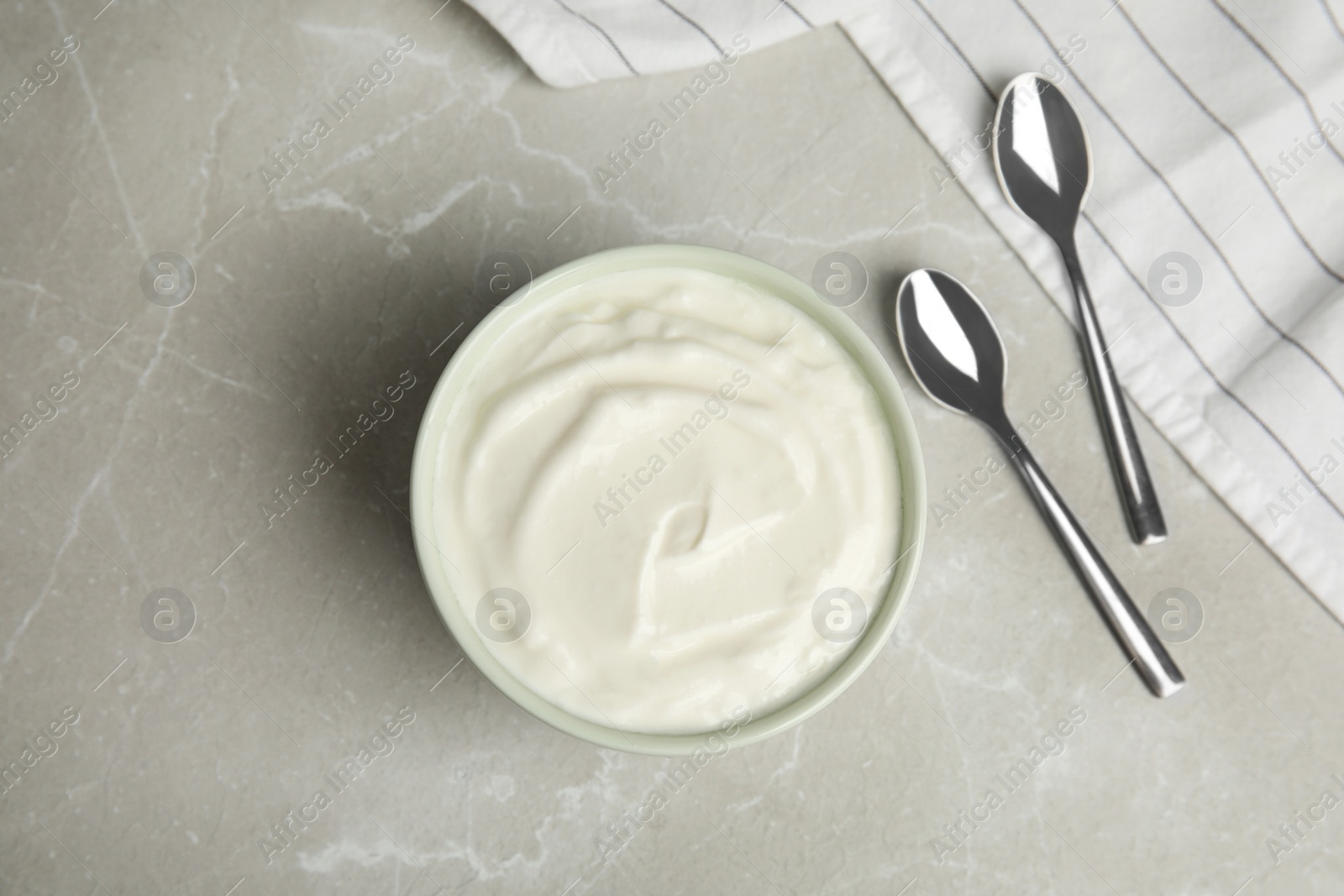 Photo of Tasty organic yogurt on grey marble table, flat lay