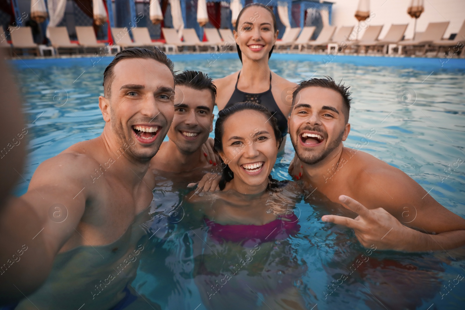 Photo of Happy young friends taking selfie in swimming pool