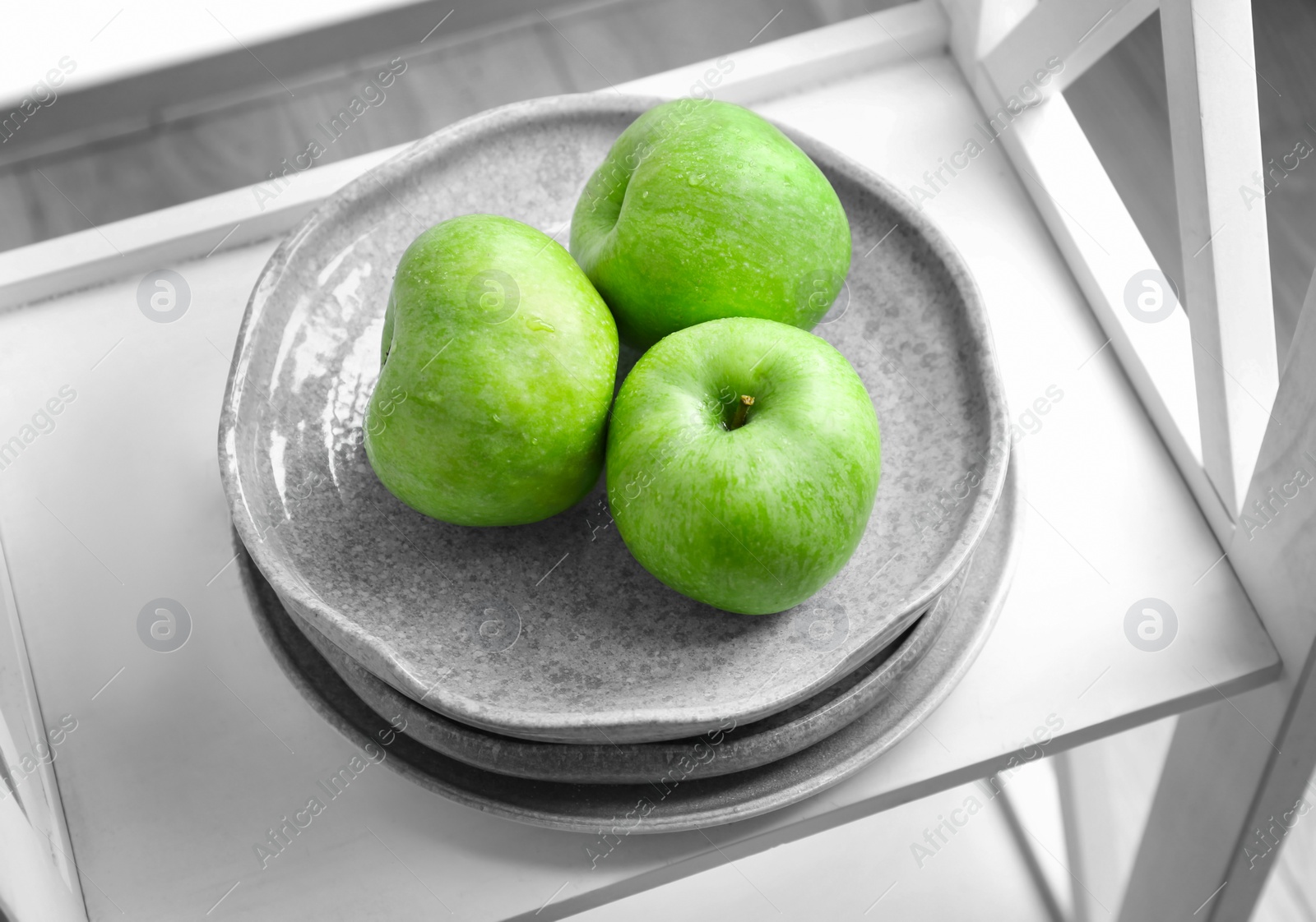 Photo of Plate with fresh green apples on shelf