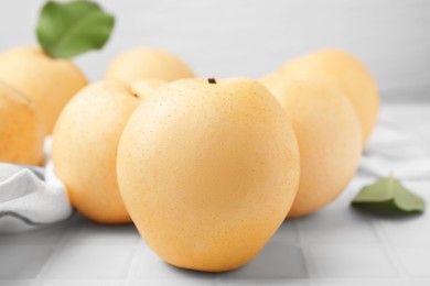 Photo of Delicious apple pears on white tiled table, closeup