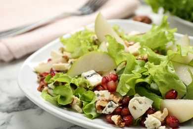 Photo of Tasty salad with pear slices on white table, closeup