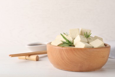 Photo of Delicious tofu with rosemary served on white wooden table. Space for text
