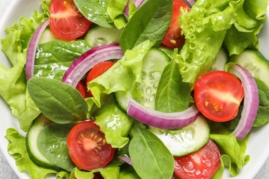 Photo of Delicious vegetable salad in white bowl, top view