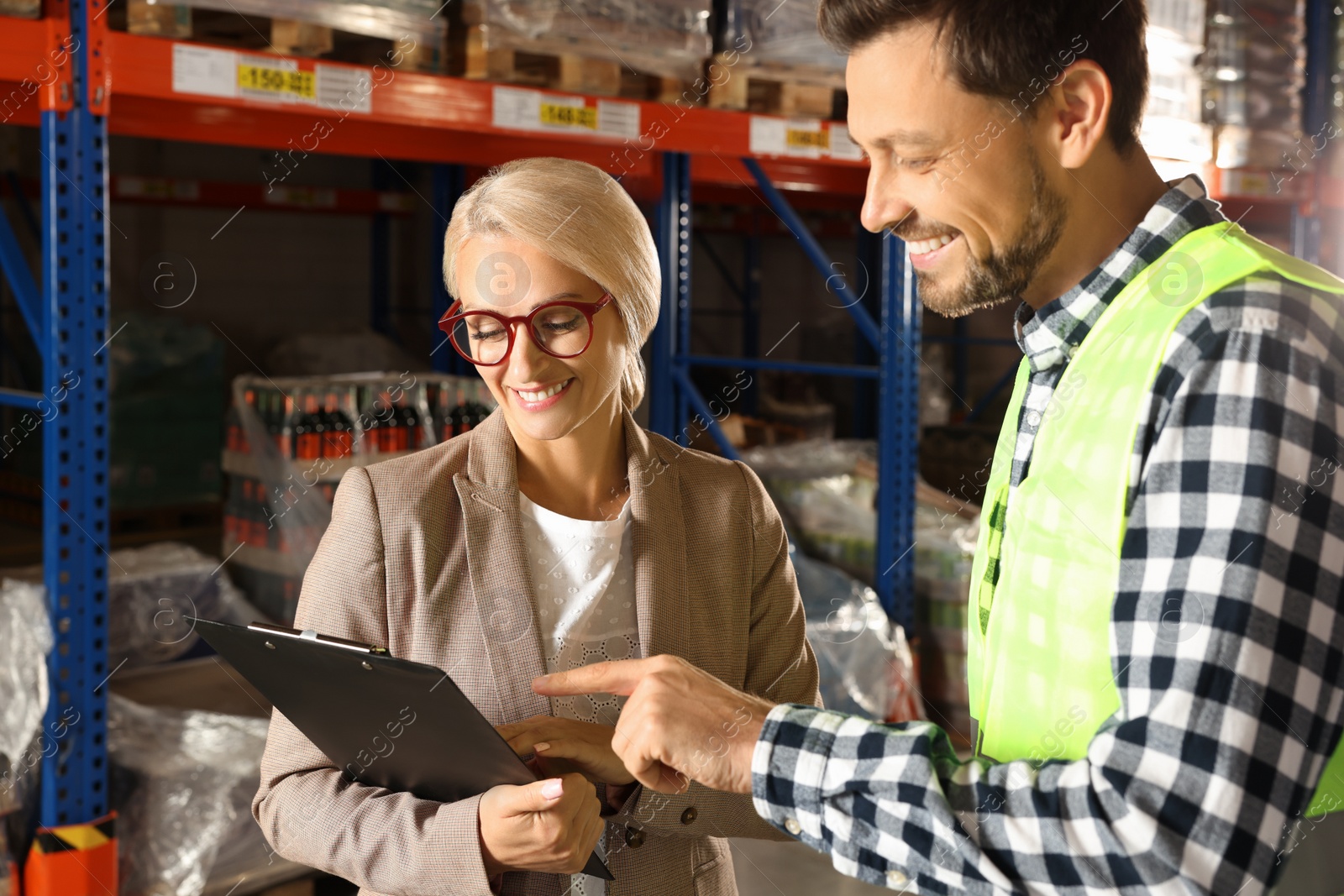 Photo of Manager and worker in warehouse with lots of products