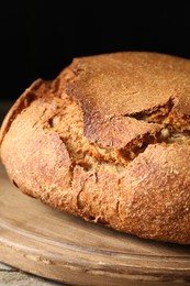 Photo of Freshly baked sourdough bread on wooden table, closeup