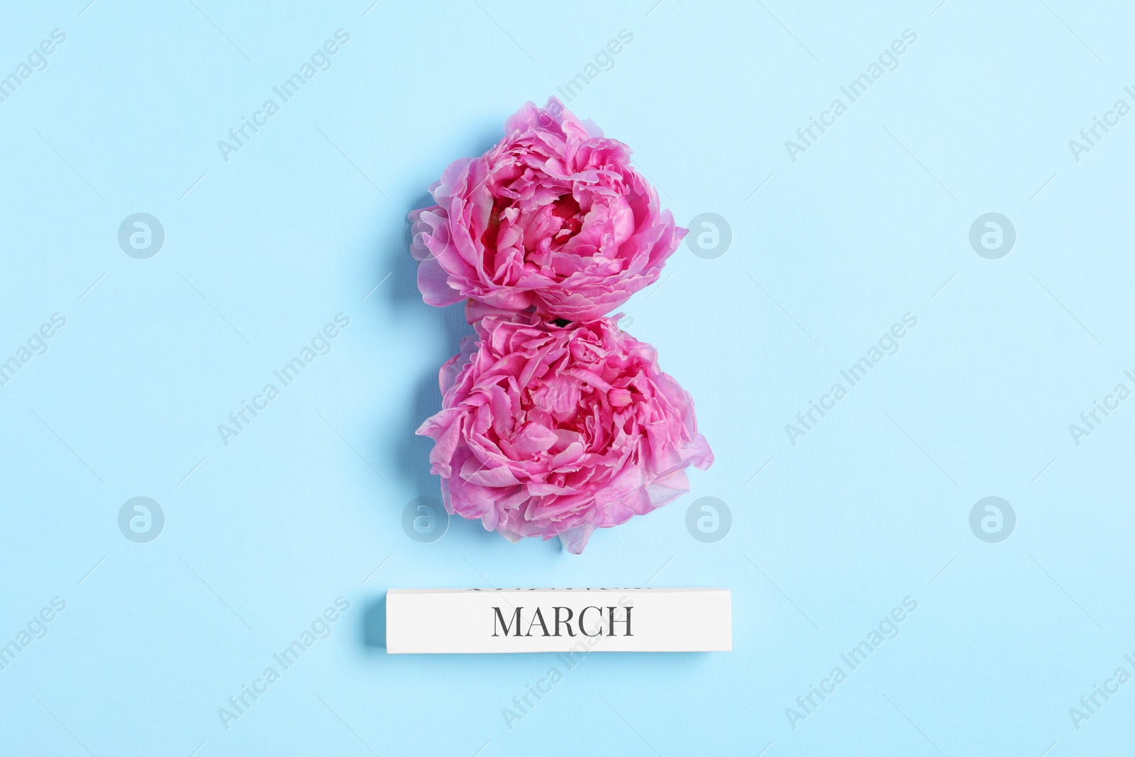 Photo of International Women's day. 8th of March made with beautiful peonies on light blue background, top view