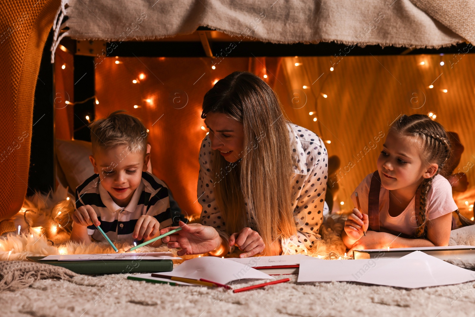 Photo of Mother and her children drawing in play tent at home