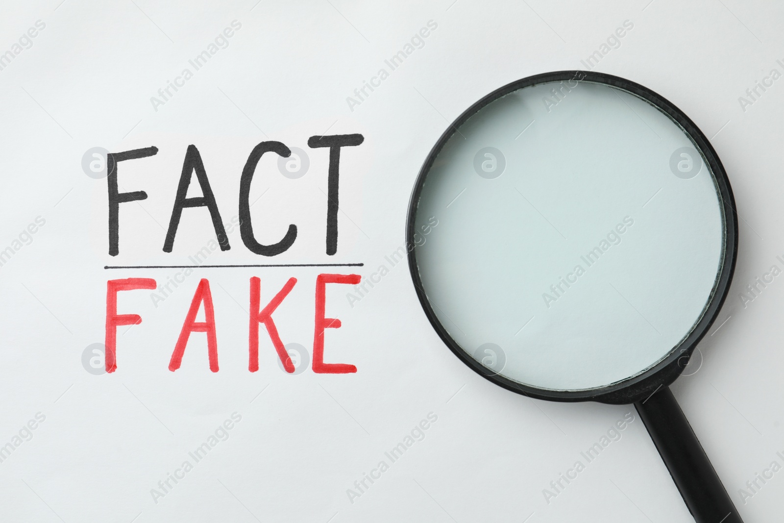 Photo of Magnifying glass near words Fact and Fake written on white background, top view