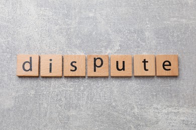 Photo of Squares with word Dispute on grey table, top view