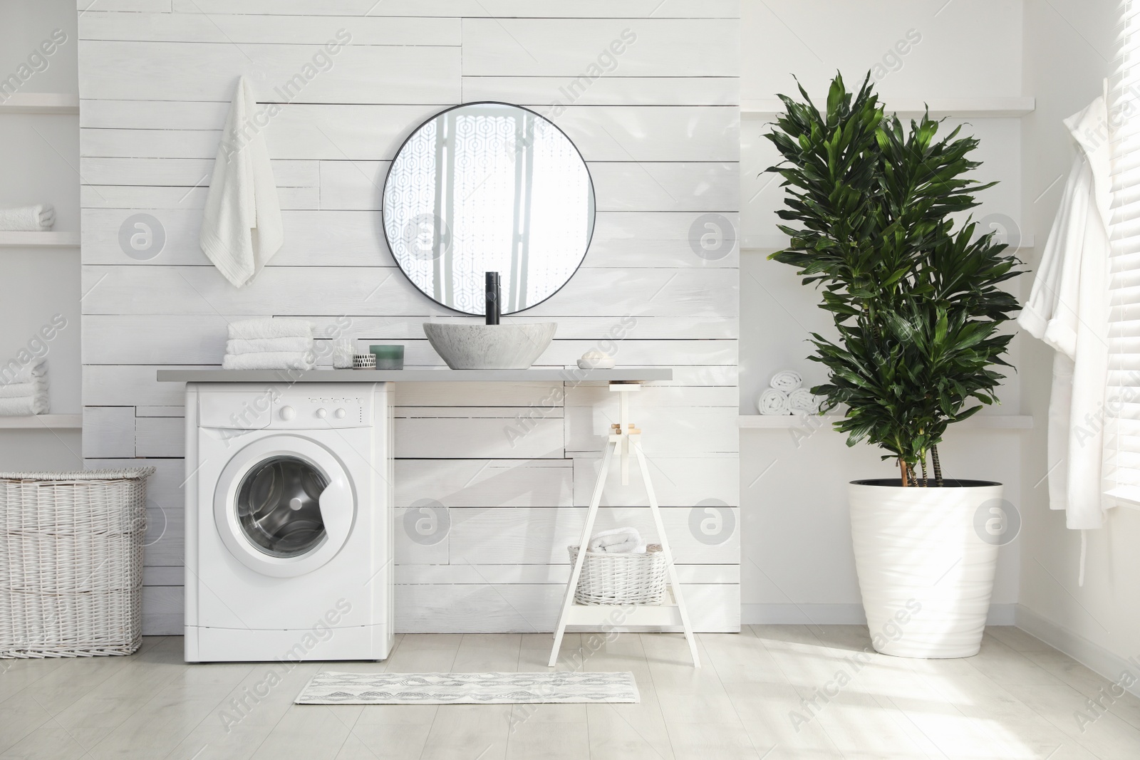 Photo of Stylish bathroom interior with modern washing machine