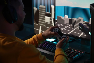 Photo of Man playing video games with controller at table indoors