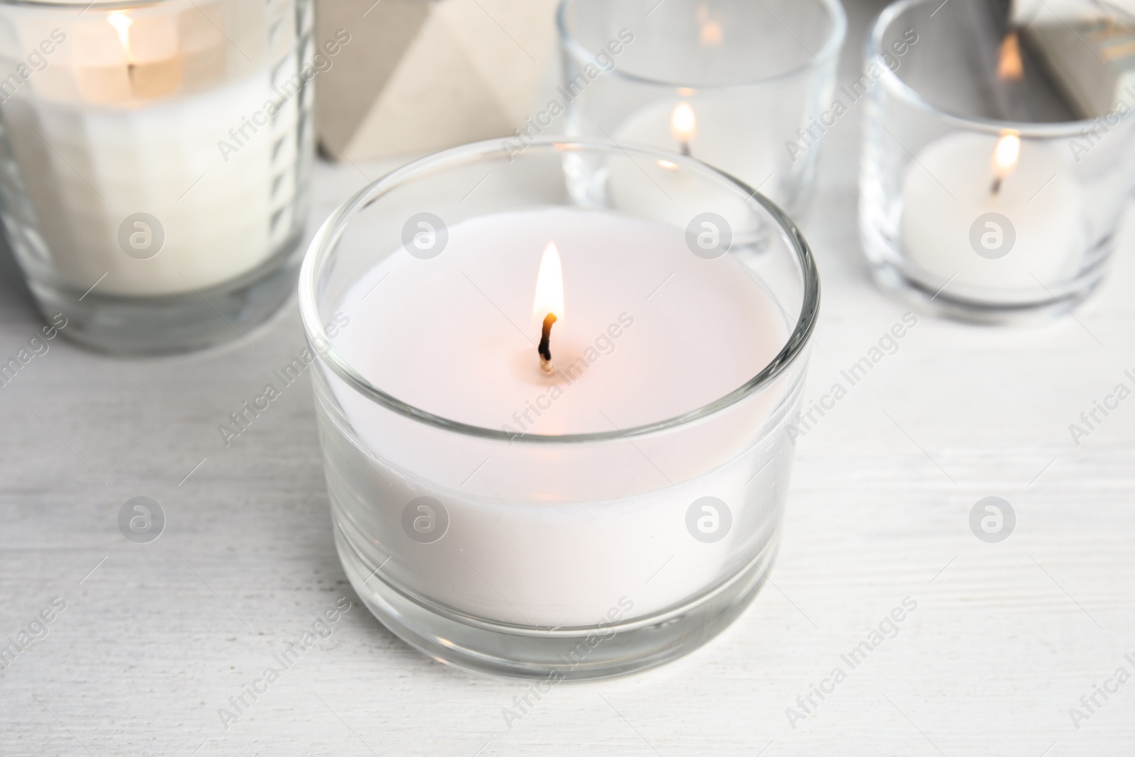 Photo of Burning aromatic candle in holder on table