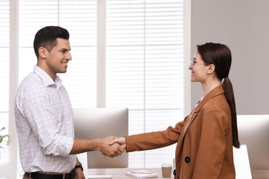 Employee shaking hands with intern in office