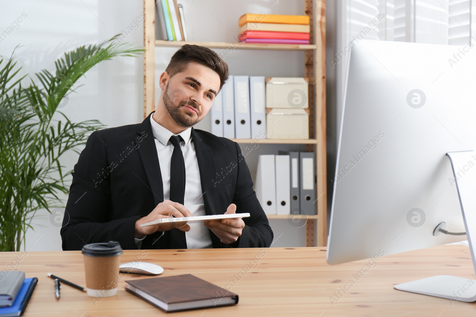 Photo of Lazy employee playing with keyboard at table in office