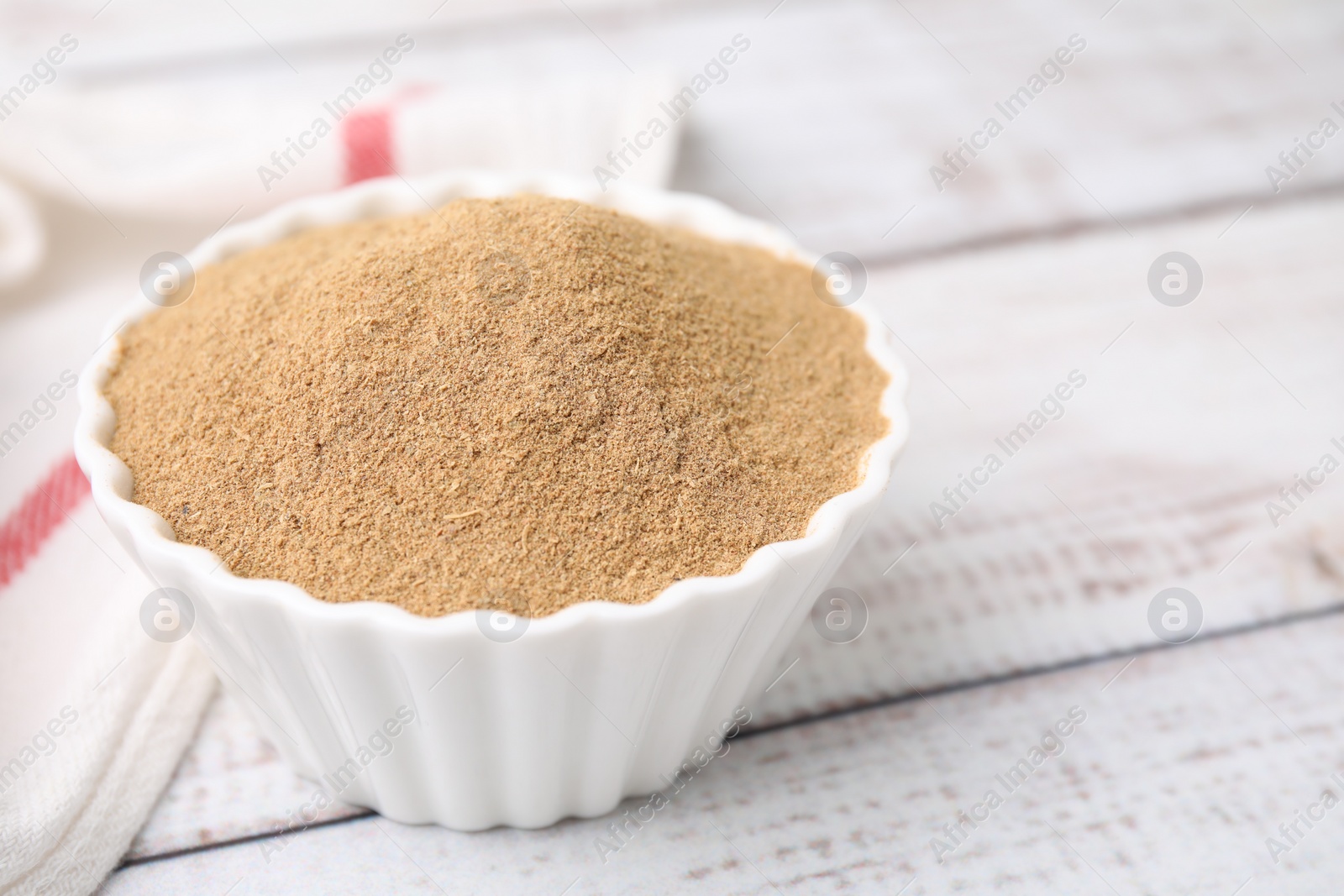 Photo of Dietary fiber. Psyllium husk powder in bowl on wooden table, closeup. Space for text