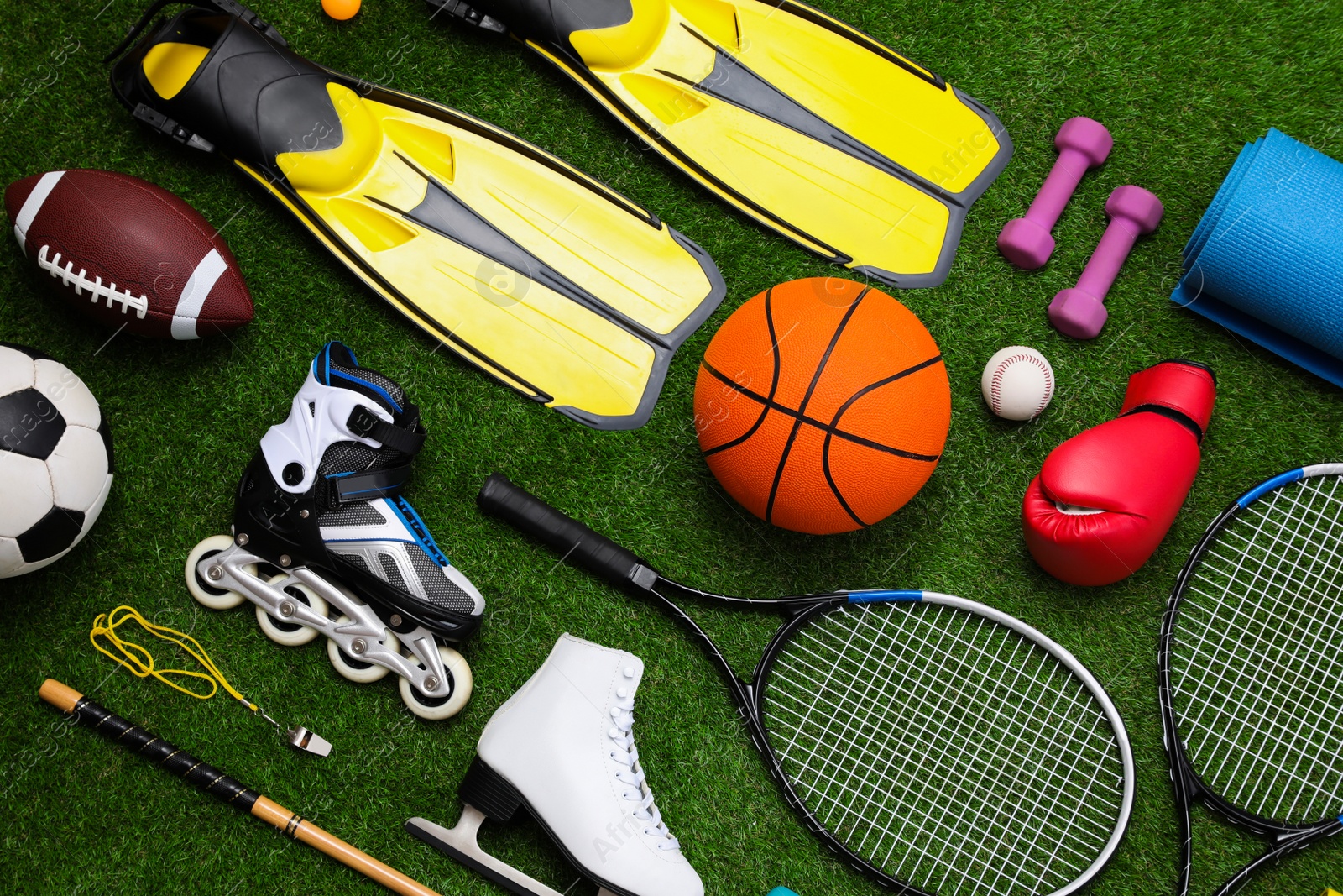 Photo of Different sport equipment on green grass, flat lay