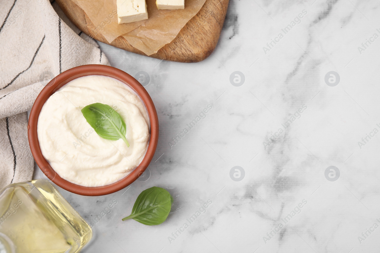 Photo of Delicious tofu sauce and basil on white marble table, flat lay. Space for text