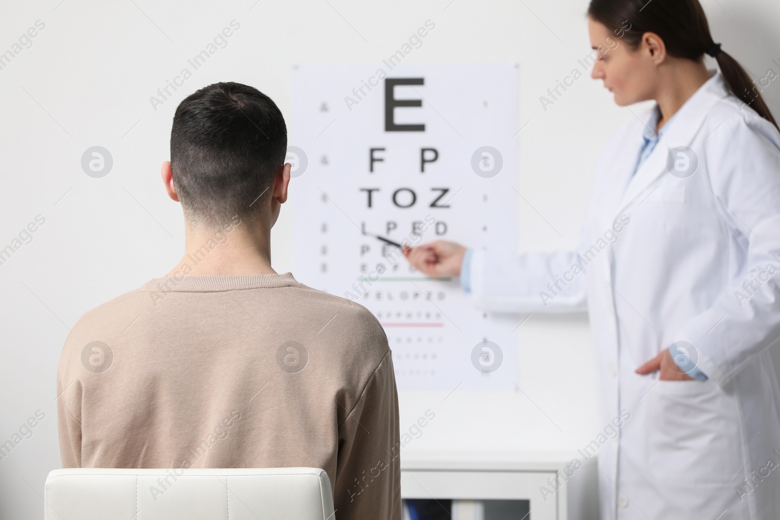 Photo of Ophthalmologist testing young man's vision in clinic
