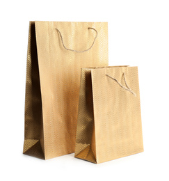 Photo of Golden paper shopping bags isolated on white. Space for design