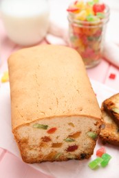 Photo of Delicious cake with candied fruits on pink table, closeup