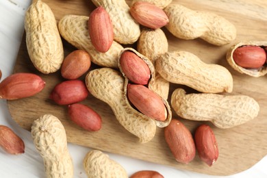 Fresh unpeeled peanuts on white table, top view