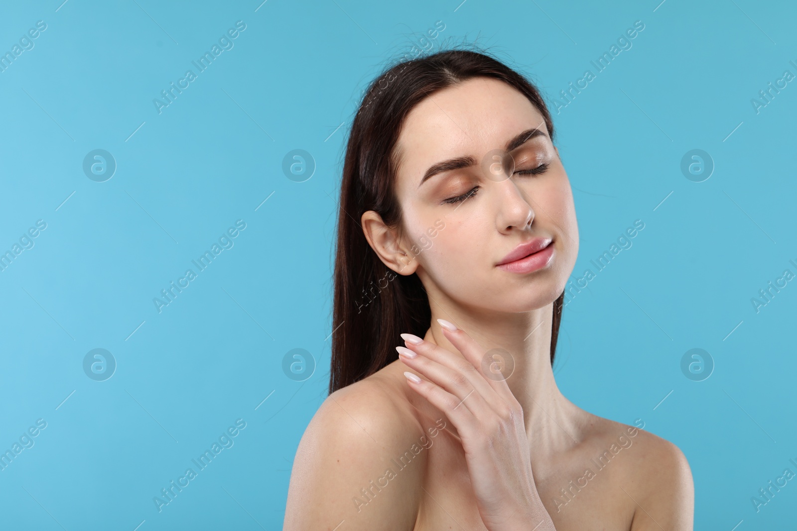 Photo of Portrait of beautiful young woman on light blue background. Space for text