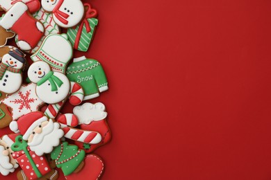 Different Christmas gingerbread cookies on red background, flat lay. Space for text