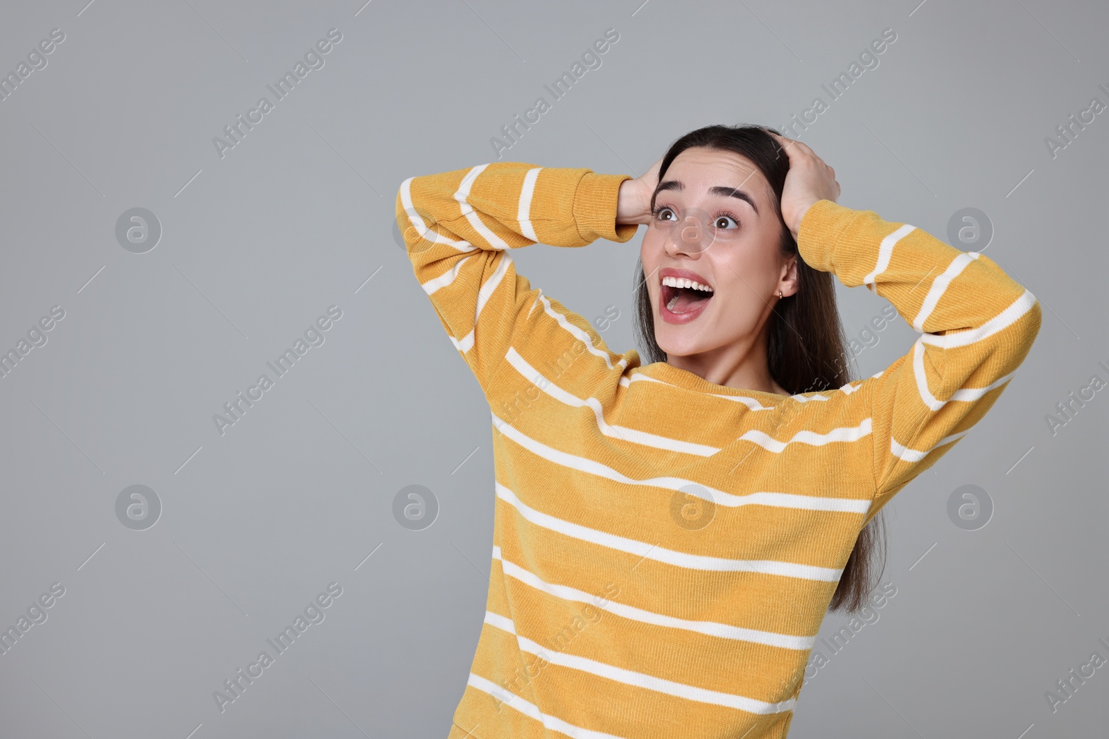 Photo of Portrait of happy surprised woman on grey background. Space for text