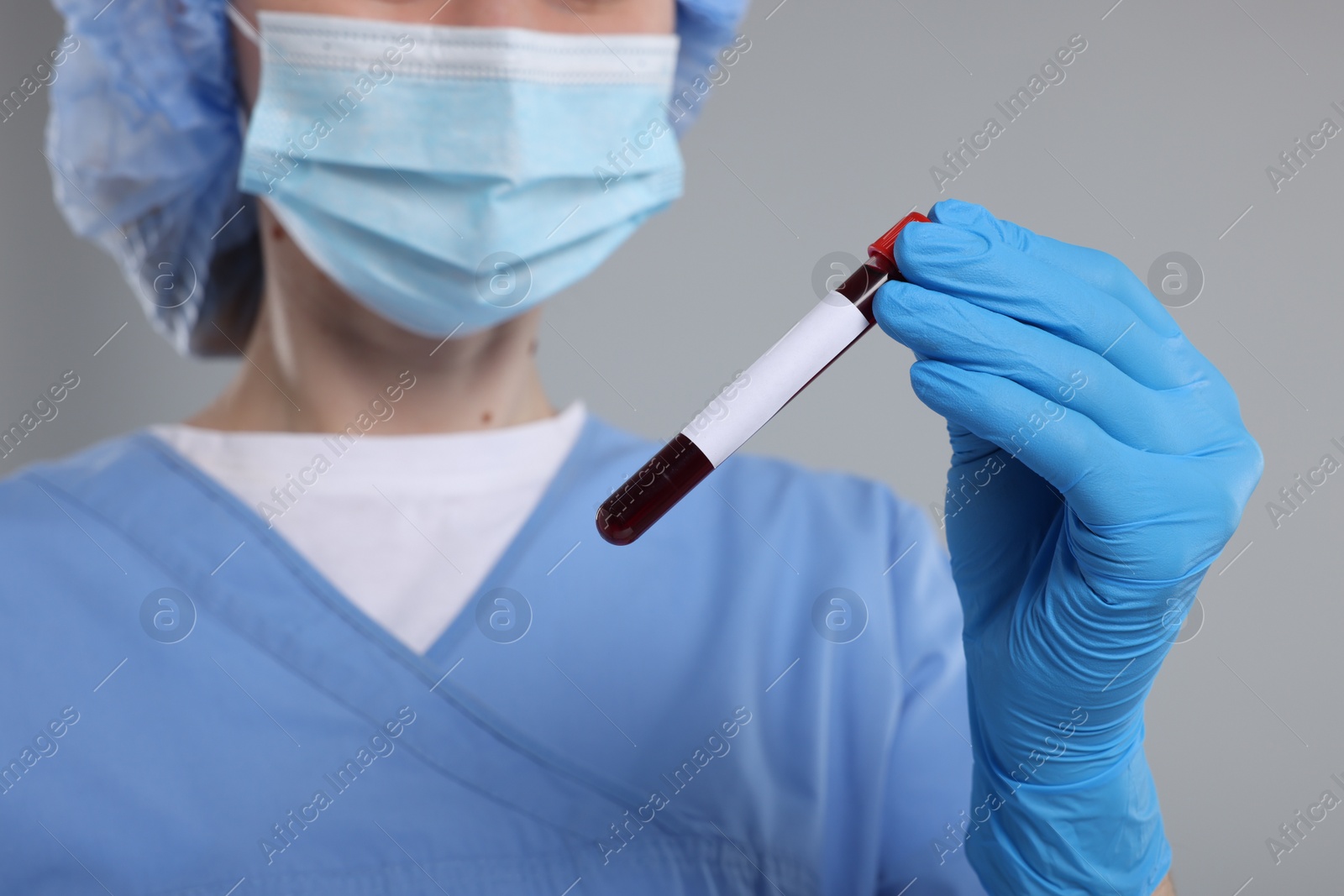 Photo of Laboratory testing. Doctor with blood sample in tube on light grey background, closeup